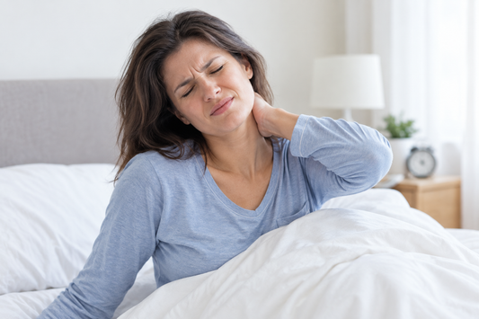 The lady wakes up with neck pain because her pillow doesn't provide the proper support for her neck.