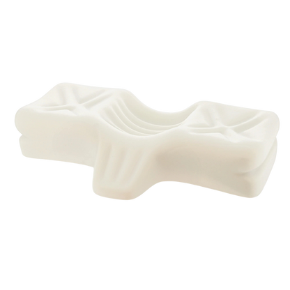 Close-up view of a contoured chiropractic pillow made from resilient molded foam, designed with ergonomic grooves to support natural neck and head alignment for pain relief.
