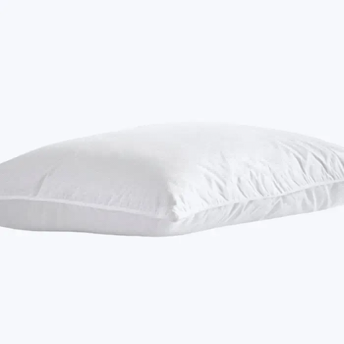 Side view of a white adjustable water pillow on a plain background, displaying its gently contoured shape and soft cover.